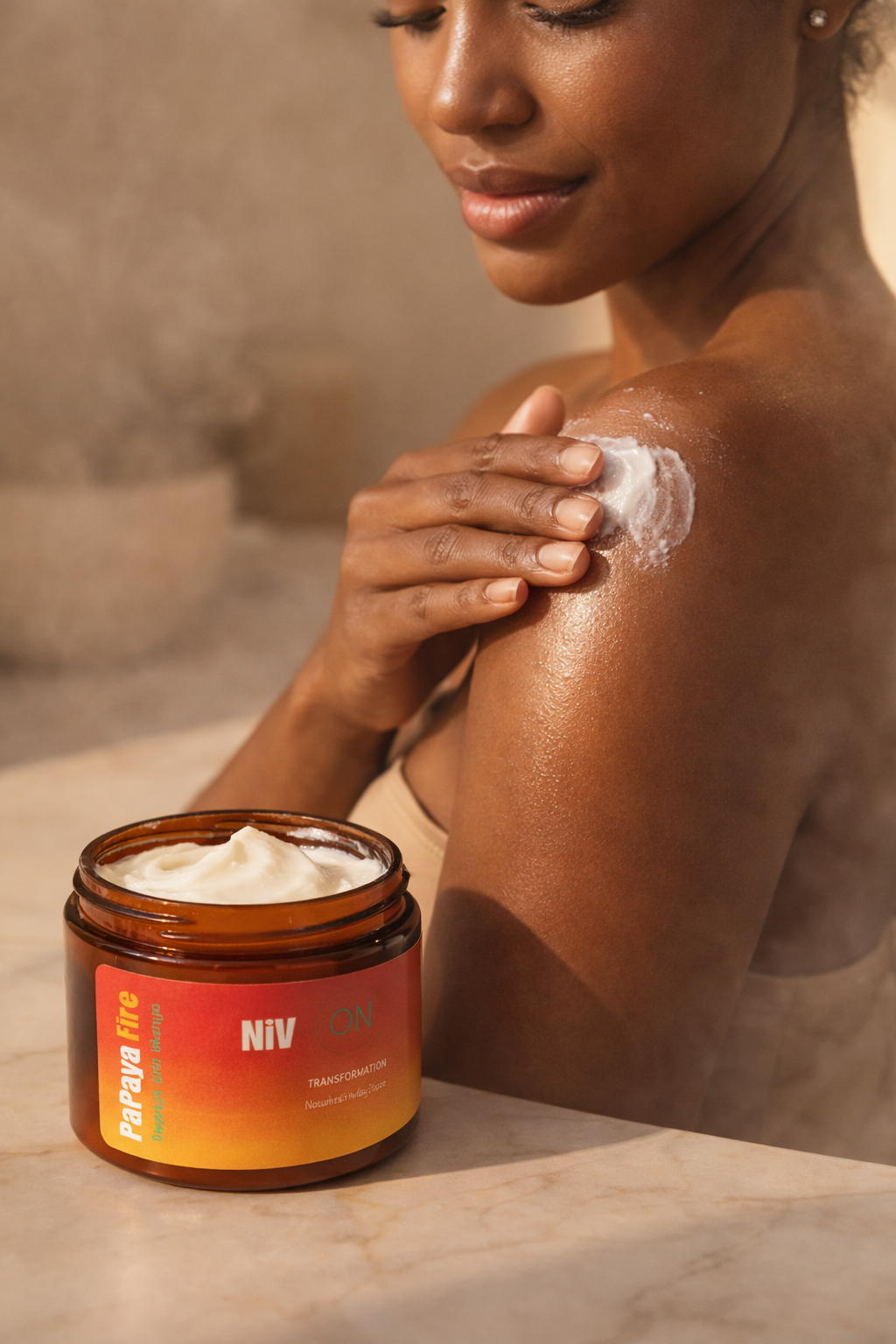 Woman applying NIV cream to her shoulder with a jar of the cream on a marble surface.